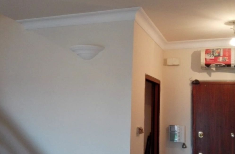 Ingresso con cornici in gesso al soffitto e pareti tinteggiate